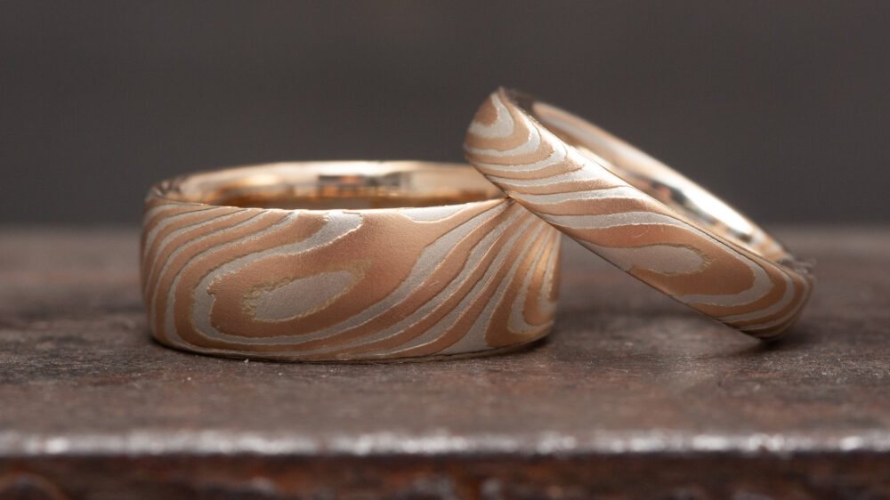 Exceptional wedding rings made of rose gold and silver. Both rings are made from a single piece and cut in half, ensuring the grain is continuous on both rings.