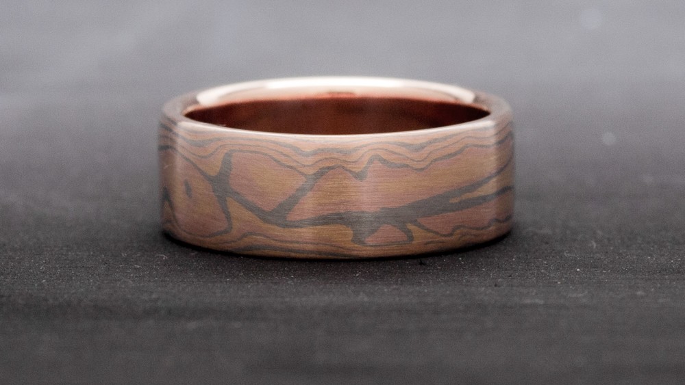 ring aus Gelbgold mit rotgold und palladium. gemustert. sieht aus wie Feuer.